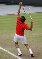 Image of a man serving a tennis ball