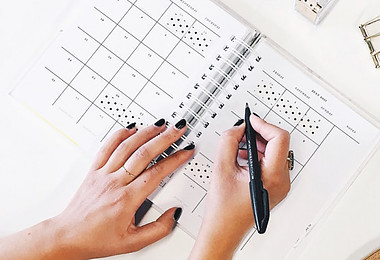 Imeage of woman's hands checking off box in calendar