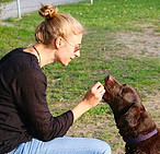 Image of woman giving dog a treat