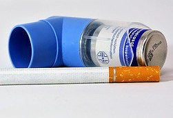 Image of an inhaler lying next to a cigarette